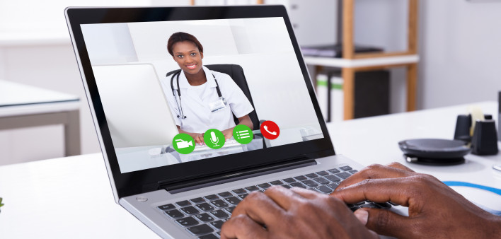Close-up Of A Person Video Conferencing With Female Doctor Through Laptop