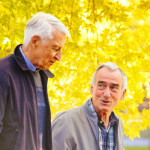 Senior gay couple enjoying a walk sunny Autumn day