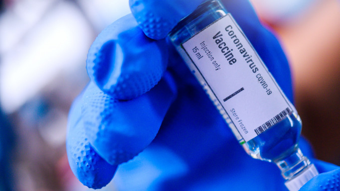 Image of Hand holds Coronavirus Covid-19 Vaccine glass bottle.