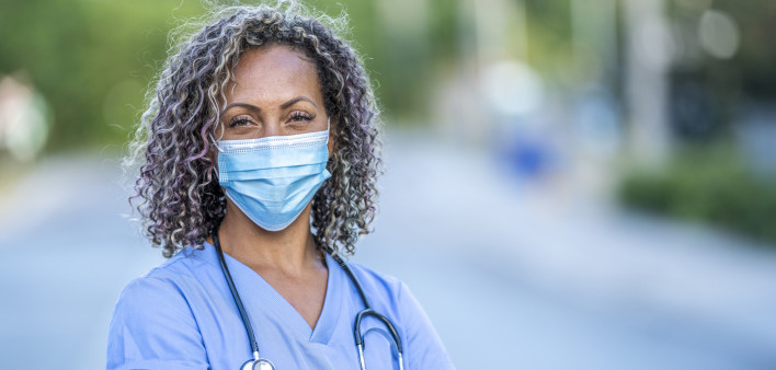 Portrait of an African American nurse wearing a protective face mask to avoid the transfer of germs during the COVID-19 outbreak.