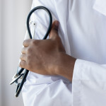 Male african american black professional doctor physician general practitioner wear white medical coat holding stethoscope, medicine and health care