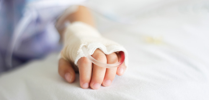 Saline intravenous (iv) drip in a Children's patient hand