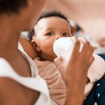 Shot of a mother feeding her adorable infant daughter at home