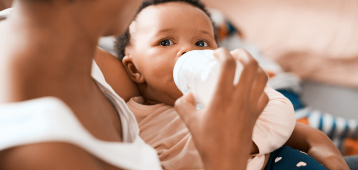 Shot of a mother feeding her adorable infant daughter at home