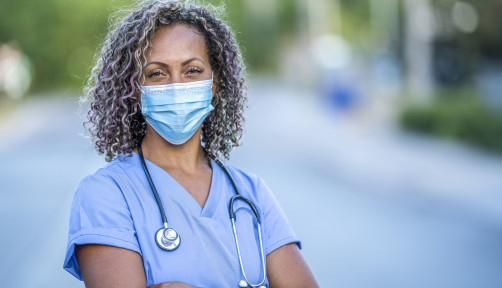 Portrait of an African American nurse wearing a protective face mask to avoid the transfer of germs during the COVID-19 outbreak.
