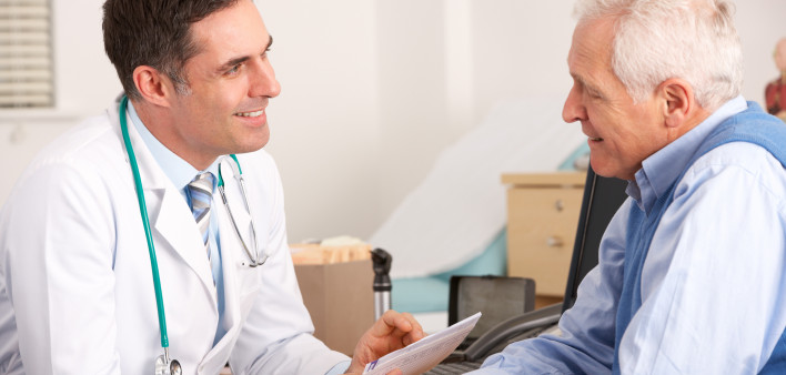 American doctor talking to senior man in surgery