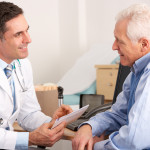 American doctor talking to senior man in surgery