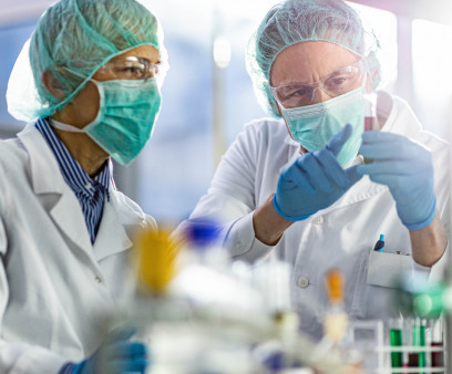 Two scientists cooperating while examining antiviral drug in a test tube at laboratory