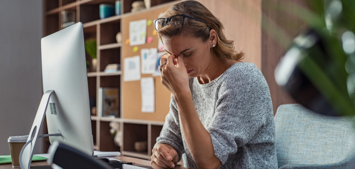 Exhausted businesswoman having a headache in modern office.