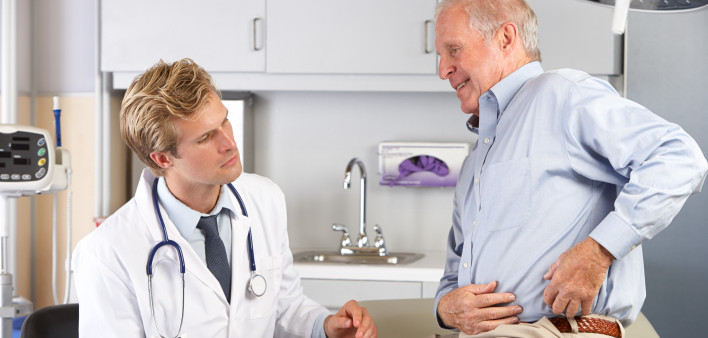 Male Doctor Examining Male senior Patient With Hip Pain