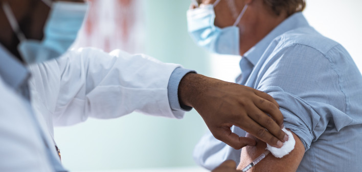 Close up of a mature man taking a vaccine in his doctors office