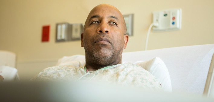 man in bed in hospital contemplative