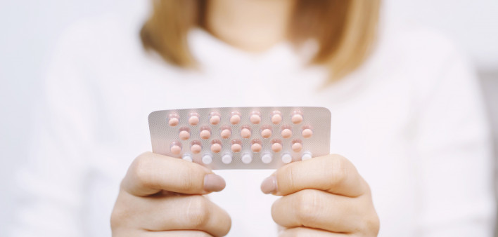 Woman hands opening birth control pills