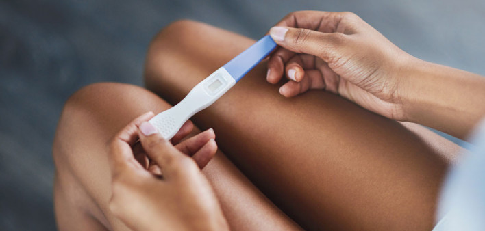 womans hands holding pregnancy test