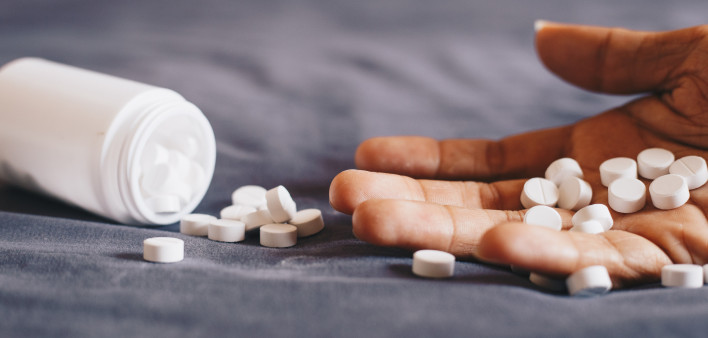 medication in hand, committing suicide by overdosing on medication