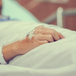 Close up patient man hand with label and drip (IV saline tube) waiting for operation of chemotherapy medical , healthcare and cancer