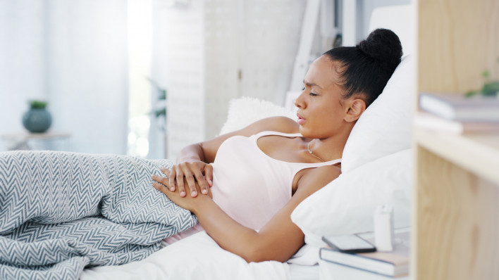 woman girl stomach cramps couch