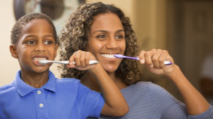 woman and boy brush teeth