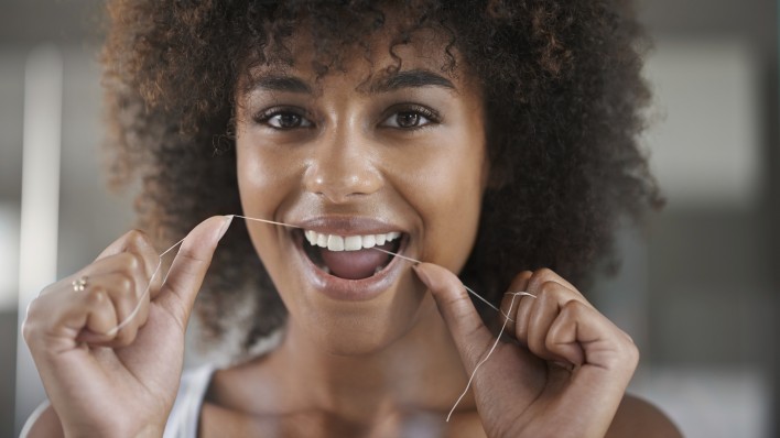 woman flossing teeth