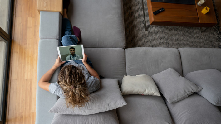 Woman at home talking with her doctor via online video call