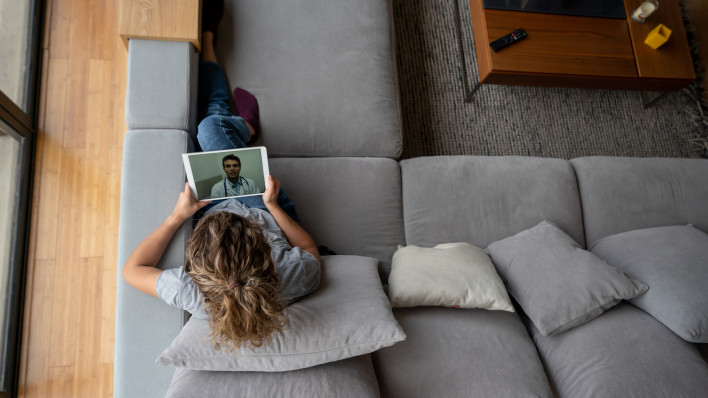 Woman at home talking with her doctor via online video call
