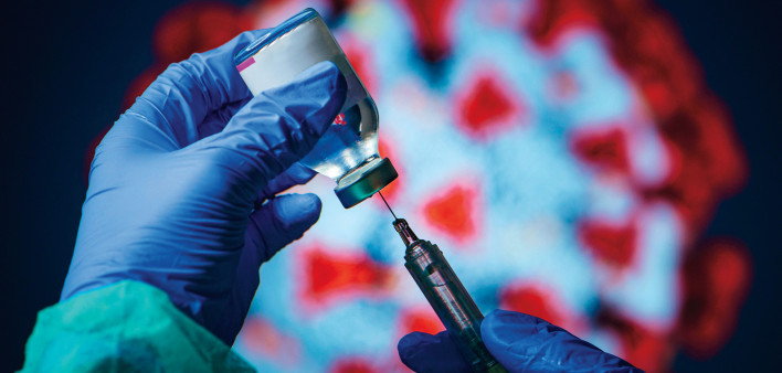 gloved hand needle vial vaccine coronavirus