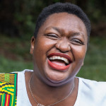 Two friends enjoying a laughing while having a conversation on a park bench in Nairobi, Kenya, the woman on the right is living with HIV