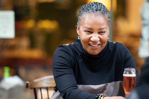Woman living with HIV laughing over drinks with a friend in London
