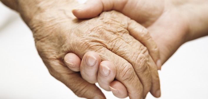 one hand holds the other elderly hand