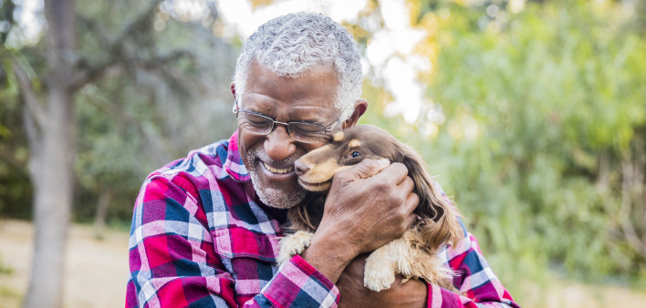 older man holding a dog