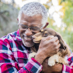 older man holding a dog