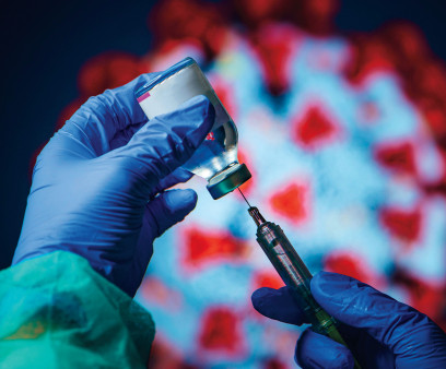 gloved hand needle vial vaccine coronavirus