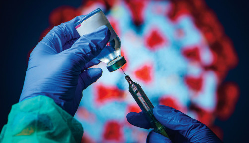gloved hand needle vial vaccine coronavirus