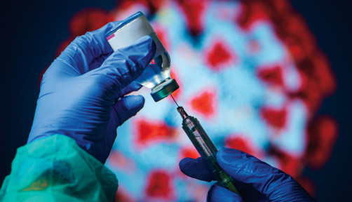 gloved hand needle vial vaccine coronavirus