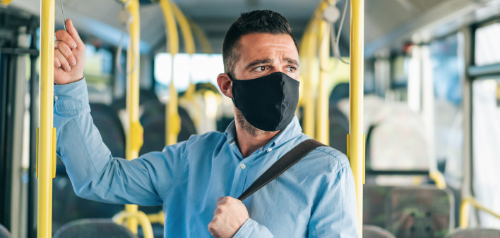 Men with protective face mask traveling with bus, during COVID-19