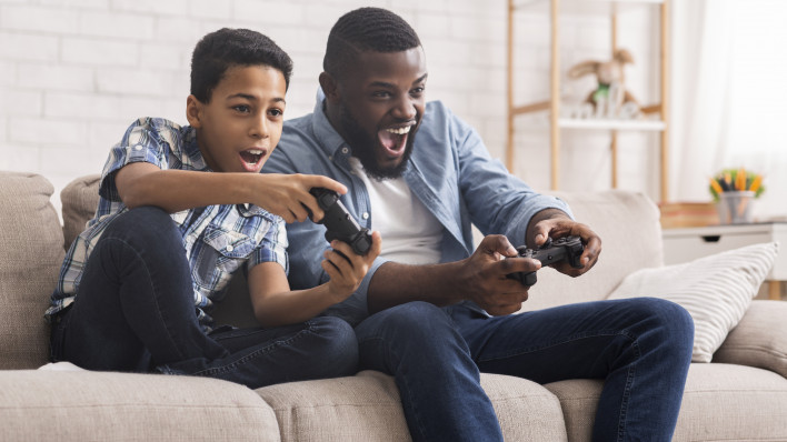 Leisure With Dad. Cheerful Black Father And Son Competing With Each Other In Video Games, Using Joysticks, Having Fun At Home,
