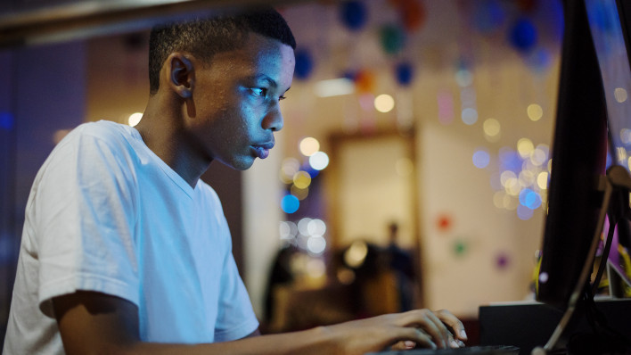 African american boy using a computer at night