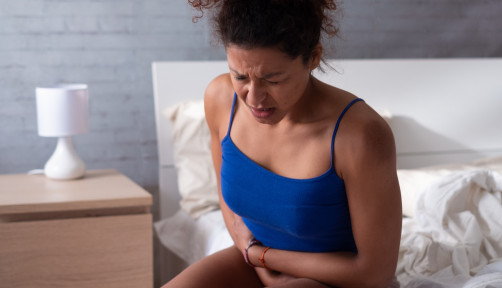 woman girl stomach cramps bed