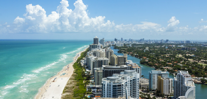 Looking down South Beach in Miami. Full view of the beach on the left and the city on the right.