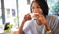 Beautiful young african woman enjoying a cup of coffee in coffee shop