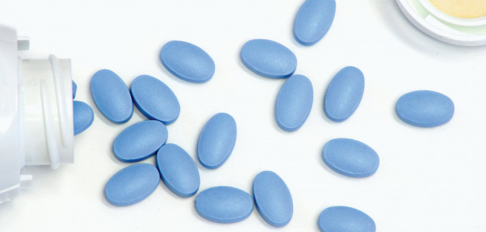 blue pills spill out of white bottle