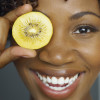 woman hold fruit up over eye