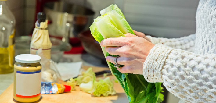 A woman making a Ceaser salad for dinner.