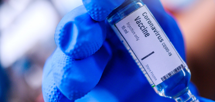 Image of Hand holds Coronavirus Covid-19 Vaccine glass bottle.