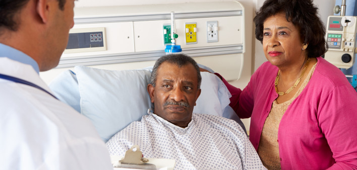 Doctor Talking To Senior Couple On Ward Worried
