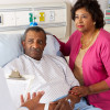 Doctor Talking To Senior Couple On Ward Worried