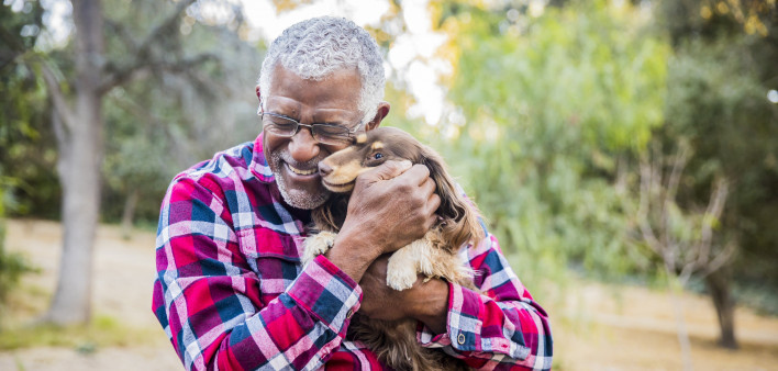 older man holding a dog