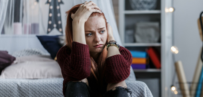 young woman depress holding head in bedroom
