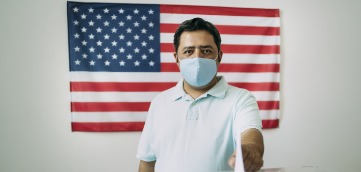 Middle aged Mexican man with protective face mask voting on election day