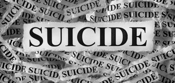 Torn pieces of paper with the words Suicide